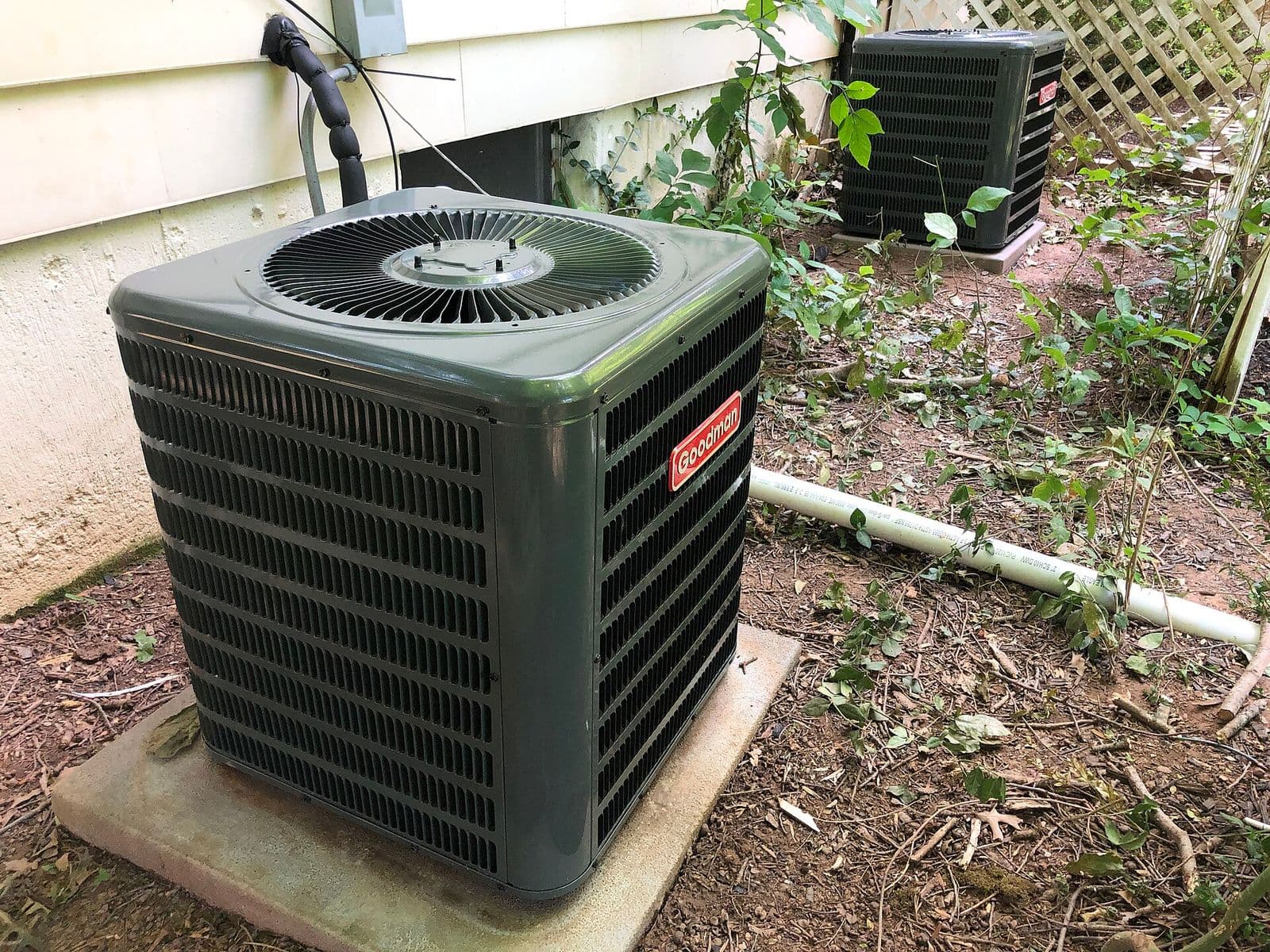 An outdoor air conditioning condenser unit beside a home